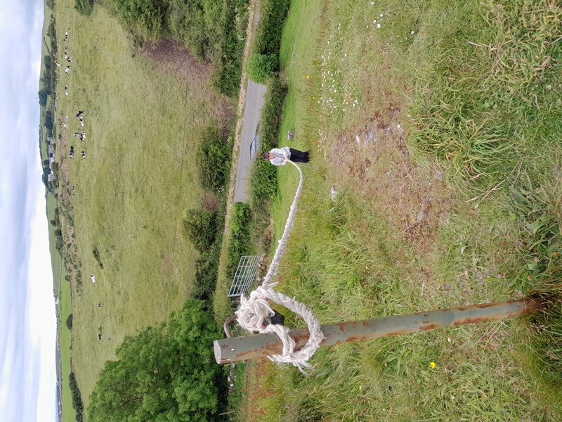 Using a rope to climb the steep sides of Druchtag Motte at Mochrum